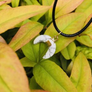 White Howlite crystal moon shaped pendant. Available on a black cord or gold plated necklace.