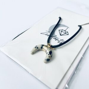 Crescent moon pendant in Dalmation Jasper crystal, within Zendants packaging.